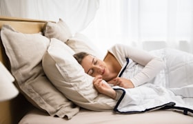 白い掛け布団でぐっすり眠る人