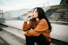 階段に座って考えごとをする女性