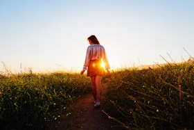 夕日の小道を歩く女性の後ろ姿