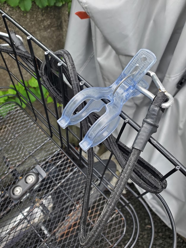 自転車の前カゴに取り付けたひったくり防止のゴムひもと竿ばさみ
